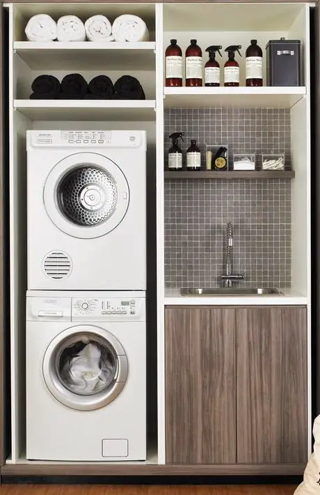 Small laundry room ideas: diy shelves and sink in tiny laundry area with stackable washer and dryer.